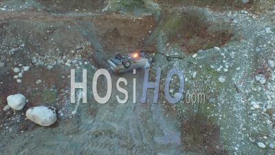Car Fire On Turned Over Vehicle At Dusk In An Abandoned Gravel Pit. - Video Drone Footage