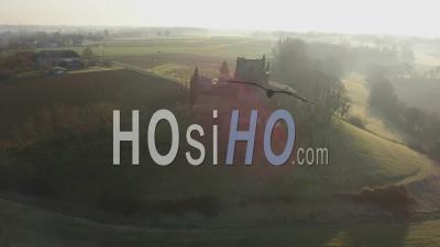 Aerial View Of Agricultural Landscape And Ruined Castle In The Middle Of Fields At Sunrise - Video Drone Footage
