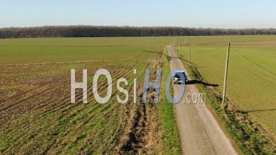 Car Driving On A Countryside Road In A Grazing Light, Video Drone Footage