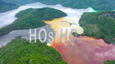 Drone View Of Copper Mining Waste Water In Contrast With Fresh Green Forest