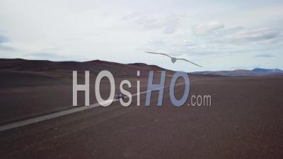 Vue Aérienne D'une Fourgonnette Noire Voyageant Sur Un Chemin De Terre à L'intérieur Des Montagnes De L'intérieur De L'islande - Vidéo Drone