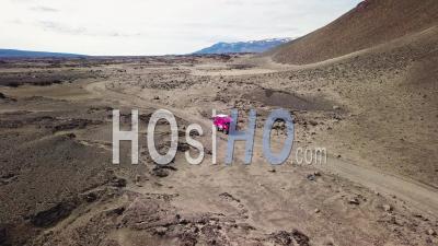 Vue Aérienne D'un Land Rover 101 Rose Traversant Les Hauts Plateaux Désertiques De L'islande - Vidéo Drone