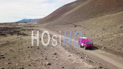 Aerial View Of A Rare Pink Land Rover 101 Driving Through The Outback Highlands Of Desolate Iceland - Video Drone Footage