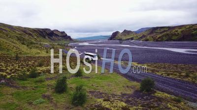 Aerial View Over A Bus Driving Beside A River In The Highlands Of Iceland - Video Drone Footage