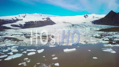 Aerial View Across The Massive Glacier Lagoon Filled With Icebergs At Fjallsarlon, Iceland, Suggests Global Warming And Climate Change - Video Drone Footage