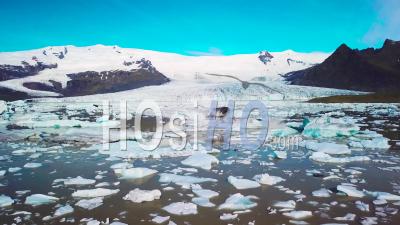 Aerial View Across The Massive Glacier Lagoon Filled With Icebergs At Fjallsarlon, Iceland, Suggests Global Warming And Climate Change - Video Drone Footage