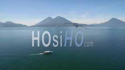 Vue Aérienne Sur Un Bateau Sur Le Lac Amatitlan Au Guatemala Révèle Le Volcan Pacaya Au Loin - Vidéo Drone