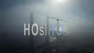 Aerial View Over Large Power Plant Smokestacks In The Fog Near Morro Bay, California - Video Drone Footage