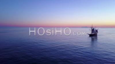 Aerial View Of A Tall Sailing Ships On The Open Ocean At Sunset - Video Drone Footage