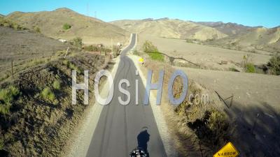 Vue Aérienne Sur Un Homme Conduisant Sa Moto Harley Sur La Route Ouverte - Vidéo Drone