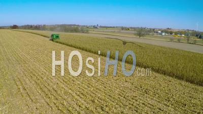 Aerial View Over A Rural American Farm With Corn Combine Harvester At Work In The Fields - Video Drone Footage