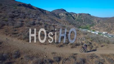 Aerial View Of A Mountain Biker Ascending A California Mountain - Video Drone Footage