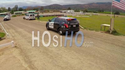 Aerial View Above A K9 Dog In Training In A Mock Shootout Between Police And Criminals - Video Drone Footage