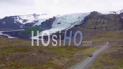 Vue Aérienne Sur Un Camion De Camping Noir Conduisant à Un Glacier Dans Les Montagnes De L'islande - Vidéo Drone