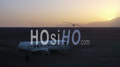 Vue Aérienne D'un Homme Debout Sur Un Crash De La Marine Américaine Dc-3 Sur Le Sable Noir De Solheimasandur, Islande - Vidéo Drone