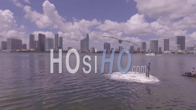 A Man Hovers Using A Water Jetpack Flyboard On The Ocean In Miami, Florida - Video Drone Footage