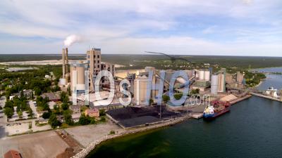 Aerial Over Ocean With Cement Factory Background, Sweden - Video Drone Footage