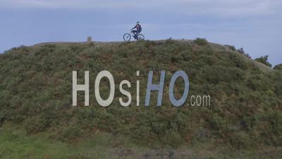 Cycliste Tout Terrain Au Sommet De La Colline, Observant L'environnement Avant De Descendre - Vidéo Drone