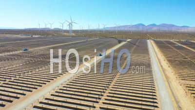 Une Ferme Solaire Révèle Un Parc éolien Au Loin, Le Désert De Mojave, En Californie, Suggère Des Sources D'énergie Renouvelables Vertes Propres - Vidéo Aérienne Par Drone