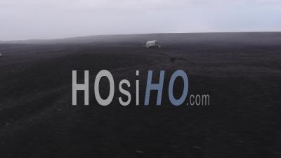Wrecked Plane With People Around, On A Black Dirt Beach, Iceland - Video Drone Footage