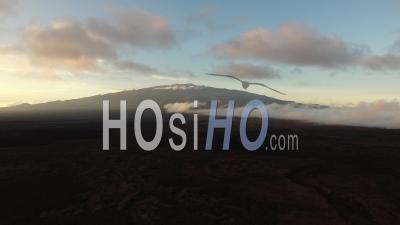 Large View Of The Sunset Behind Mauna Loa Volcano Coming Out The Clouds, Hawaii - Video Drone Footage