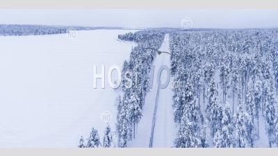 Conditions Routières Dangereuses De La Route D'hiver Couverte De Neige Glacée Dans Le Cercle Polaire Arctique En Laponie, Finlande Drone