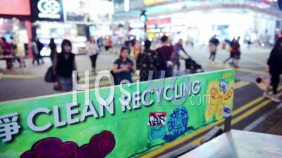 Closeup View Of A Clean Recycling Signage In A Colorful Board In Hong Kong With Pedestrians Crossing In The Blurry Background - Timelapse