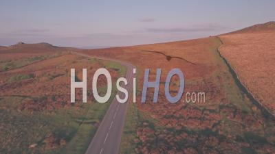 Car Driving Through Dartmoor National Park, Devon, England, Uk. Aerial Drone Following Car