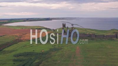 Dunstanburgh Castle At Sunset, A Famous Landmark In Northumberland, England, Uk. Aerial Drone View