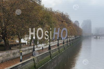 London In Coronavirus Covid-19 Lockdown With Person Running And Jogging Along River Thames On South Bank With Autumn Trees In Atmospheric Misty Weather In England, Uk At Rush Hour