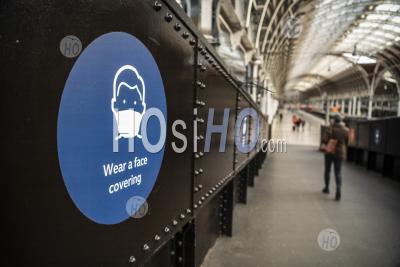 Coronavirus Covid-19 Information Sign Saying Wear A Face Covering Mask At Paddington Train Station In London When Public Transport Was Quiet And Deserted With No People In England, Europe