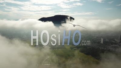 Aerial Panning And Move Backward Into The Cloud At Penan - Video Drone Footage