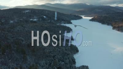 Waterbury Vermont Frozen Lake, New England Forest And Mountains In Winter At Sunset - Video Drone Footage
