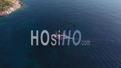 Aerial Drone View Of A Tourist Cruise Ship Sailing Near The Rocky Mediterranean Coast Of The Greek Island
