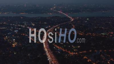 Highway Freeway Road Going Through Istanbul City With Red Illuminated Bosphorus Bridge In The Distance At Night, Aerial Wide View - Video Drone Footage