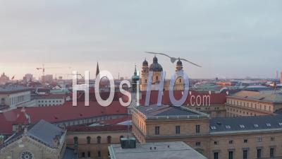 Theatine Church, Munich, Yellow Cathedral In Beautiful Sunset Golden Hour Light, Big German City On Beautiful Winter Day With Clear Sky, Aerial Dolly In Flight Above Red Rooftops - Video Drone Footage