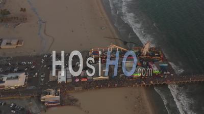 Encerclant La Jetée De Santa Monica, Los Angeles D'en Haut Au Beau Coucher De Soleil Avec Des Touristes, Des Piétons S'amusant Au Parc à Thème Grande Roue Avec Vue Sur L'océan Vagues S'écraser 4k - Vidéo Aérienne Par Drone
