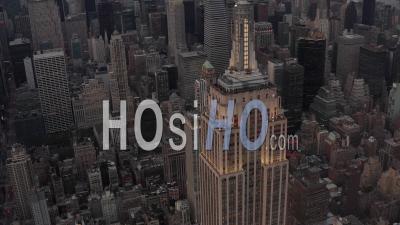 Aerial View Flying Away From The Empire State Building In The Evening Lights With Skyscrapers And Office Buildings In The Background 4k - Video Drone Footage