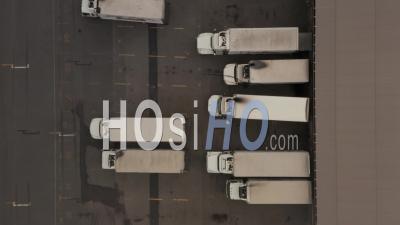 Top Down Aerial Overhead Birds Eye View Of Truck Driver Fixing Parked Truck And Truck Parking Backwards At A Large Industrial Harbor Parking Lot 4k - Video Drone Footage