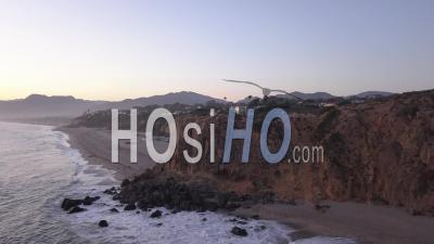 Flight Over Malibu, California View Of Beach Shore Line Pacific Ocean At Sunset With Mountain Cliff In Beautiful 4k - Video Drone Footage