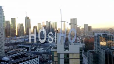 Aerial View Confident Young Man, Guy Standing On Rooftop In Skyline Of Frankfurt Am Main, Germany With Beautiful Sunlight In Winter Haze 4k - Video Drone Footage