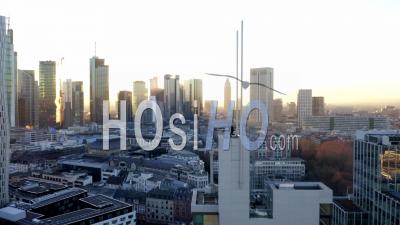 Aerial View Confident Young Man, Guy Walking On Rooftop In Skyline Of Frankfurt Am Main, Germany With Beautiful Sunlight In Winter Haze 4k - Video Drone Footage