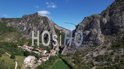 The Village Of Sigottier In The Buëch Valley, At The Foot Of A Rocky Cliff, Hautes-Alpes, France, Viewed From Drone