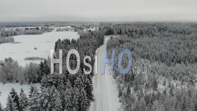 Snowy Road Through The Frosty Forest - Video Drone Footage
