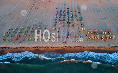 Sunset View Of A Sandy Mediterranean Beach With Colorful Sunbeds And Umbrellas. - Aerial Photography