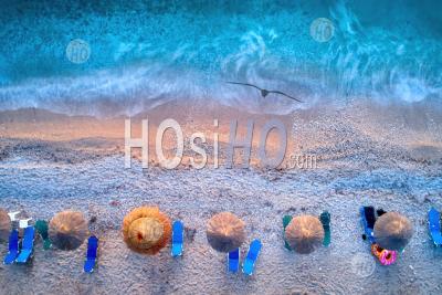 Vertical View Of Reed Umbrellas On Pebble Beach, Azure Sea And Surf. - Aerial Photography