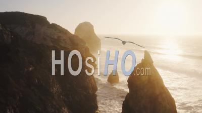 Aerial Drone View Of Dramatic Rocky Cliffs, Rock Formations, Rocks And Coastal Scenery Landscape On The Atlantic Coast Of Portugal, Europe With Orange Sunset Light