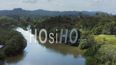Aerial Drone View Of Rainforest River And Mountains Scenery In Costa Rica At Boca Tapada, San Carlos River (rio San Carlos) That Connects To Nicaragua In Central America, High Shot Above Trees