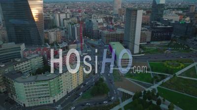 High Angle View Of Traffic On Roads And Intersections In City At Dusk. Modern Town Development Around Parco Biblioteca Degli Alberi. Milano, Italy. - Video Drone Footage