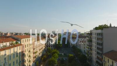 Forwards Fly Above Wide Street Lined By Trees And Rows Of Apartment Houses. Town Development At Golden Hour. Milano, Italy. - Video Drone Footage